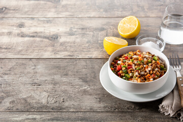 Lentil salad with peppers,onion and carrot in bowl on wooden table.Copy space