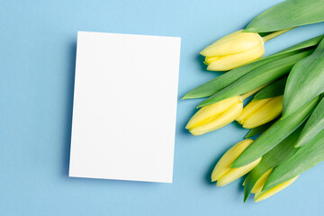 Greeting card mockup with yellow tulip flowers on blue