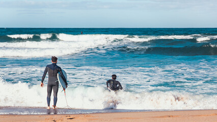 Surfers entering in the sea at Porto Paglia near Cagliari at summer