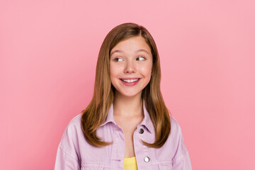 Photo of young cheerful teen girl wonder look empty space dreamy minded isolated over pink color background