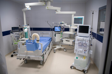 Empty Modern technology in intensive care unit room with different equipment and devices, beds and pillows.