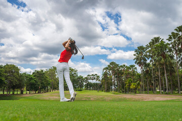 Female golf player playing golf in professional golf course.