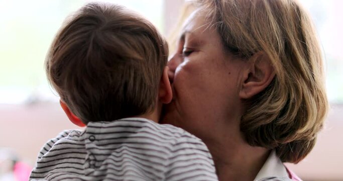 Grandmother kissing grandchild in cheek having empathy with hurt kid