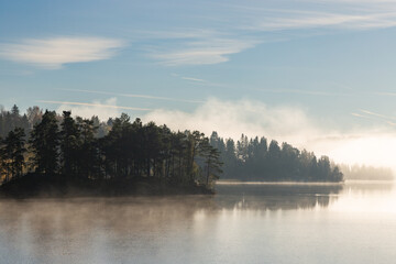 Misty and foggy autumnal morning by the calm lake