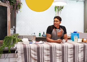 A small business owner waits behind food stall for customers