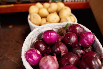 Red onions and potatoes in baskets at a vegetable market