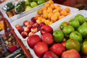 A close up of apples at a fruit and vegetable stall in a market