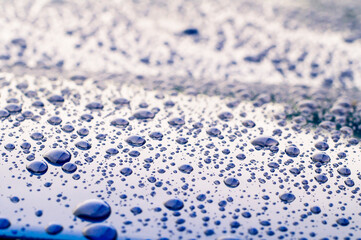 Close-up of water drops on a metalic vehicle body