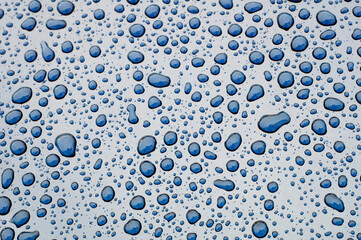 Close-up of water drops on a metalic vehicle body