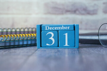 wooden calendar set on the 31 of December.