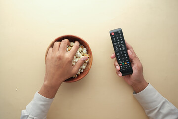 high angle view of popcorn and Tv remote on table 