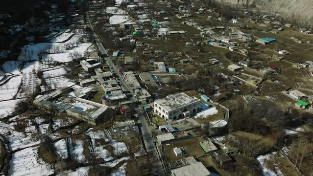 Aerial View Of Altit Fort And Hunza River In Gilgit-Baltistan, Pakistan. Karakoram mountains range in Gilgit Baltistan, Asia. Village Green gardens in mountain valley Pakistan aerial view.