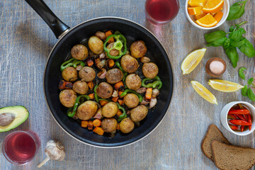 Dinner table with various snacks in the concept of homemade food, vegetables, herbs, fried steak in a pan, new potatoes