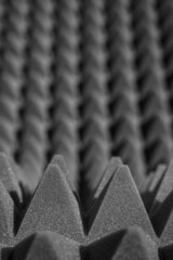 geometric black and white background of acoustic foam in the form of pyramids. Perspective abstract distortions 3d