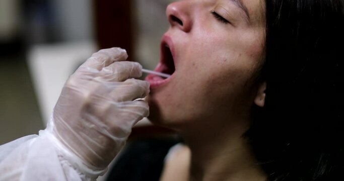 Woman having COVID mouth test PCR procedure