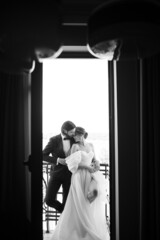 Full length portrait of people in love standing on balcony looking at each other