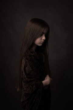Painterly dark studio portrait of a young woman in black in classic style