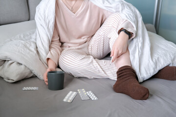 Medicine. The girl is sick at home in bed, next to pills, thermometer, medicines. Virus and temperature. Health care. Telemedicine, online doctor appointment