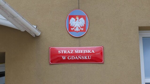 A Crowned White Eagle Emblem On The Wall In Front Of The Municipal Police Headquarter In Gdansk, Poland. - Handheld