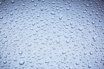 Abstract macro shot closeup of water drops on a metallic surface.