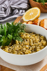 Eastern appetizer - babaganoush from eggplant with crispy bread. Eggplant dip on ceramic bowl in concrete background. Aesthetic composition with hummus. Arabic food. Oriental menu in minimal style.