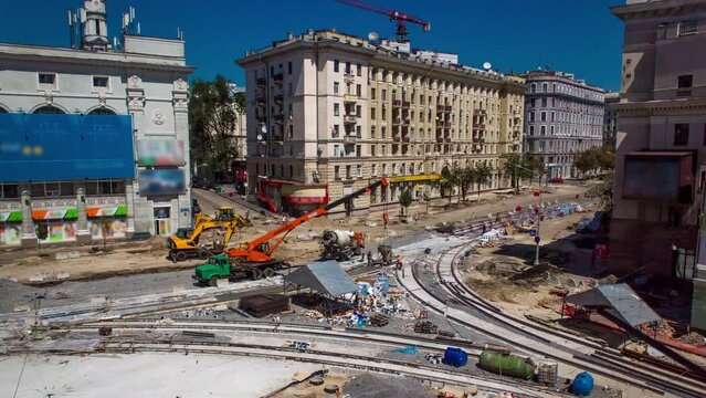 Concrete works for road intersection construction site with many workers in uniform and mixer machine timelapse. Reconstruction of tram tracks