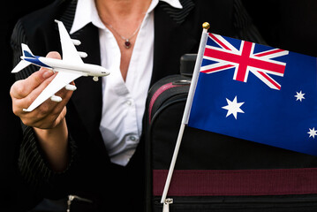 business woman holds toy plane travel bag and flag of Algeria 