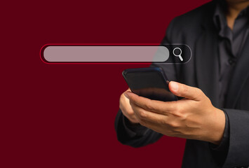 Close-up of hand a man using a smartphone to search for information interest on a search engine website while standing on a red background