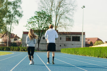 Fototapeta premium View from the back of a sports couple running in the morning at the stadium. Training Running
