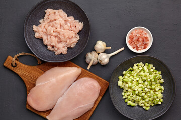 Chopped minced chicken breast fillet of poultry on a cutting board and chopped zucchini courgette