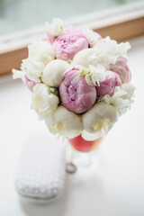 Wedding white flower bouquet for a bride on window background.