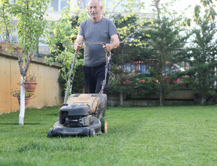 Professional Gardener with His Gasoline Lawn Mower. Professional Summer Landscaping Works.