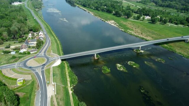 Vue a&eacute;rienne d'un fleuve avec un pont et une route parall&egrave;le