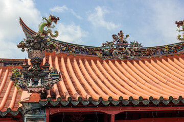 The slanted roof with ornate carvings of an ancient Chinese temple in the heritage town of Penang.