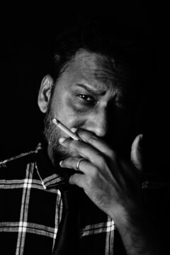 Handsome man smoking in front of black background , Santosh Kharat