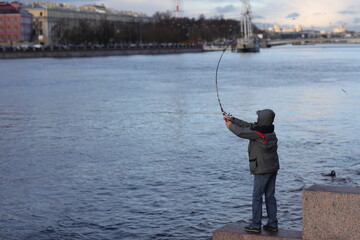 the fisherman swung his fishing rod on the banks of the Neva River, St. Petersburg
