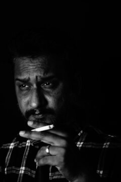 Handsome sexy man smoking cigarette in dark room , Santosh Kharat