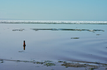 The Volga River in early spring. Ice on the river. A bottle in the water on the shore. Nature.