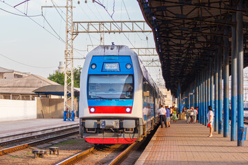 Double-decker passenger electric train Intercity arrives at the platform of the railway station....
