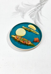 Squid yakitori in ceramic dish on white background. Japanese skewered squid with wasabi sauce. Grilled kalmar on bamboo skewer in asian style. Food menu for izakaya. Summer pan asian menu. © Ryzhkov
