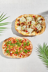 Roman pizza in modern style with asian cuisine elements. Summer set with pinsa on white background. Roman pizza with mushrooms and cheese; with chicken, avocado, coriander leaves. Fusion cuisine.
