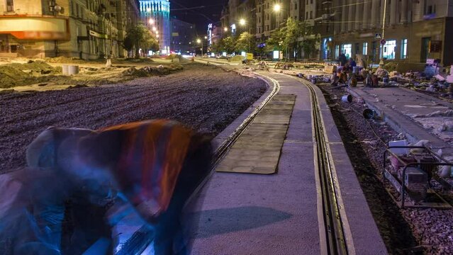 Tram rails at the final stage of their installation and integration into concrete plates on the road night timelapse in the city. Filling by liquid resin for reduction of vibration and noice. The