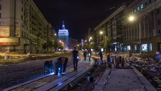Tram rails at the final stage of their installation and integration into concrete plates on the road night timelapse in the city. Filling by liquid resin for reduction of vibration and noice. The