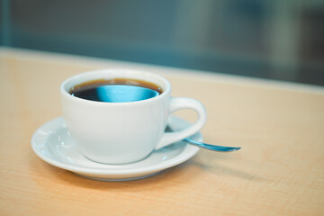 Coffee cup close up shot in a bar against a window on a wooden counter