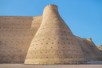 Fototapeta na wymiar Massive walls of the Ark fortress in Bukhara, Uzbekistan. Citadel is the oldest building in the city. Legends attribute the foundation of the fortress to the legendary hero Siyavush
