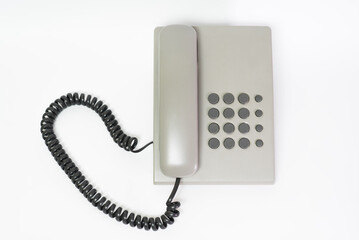 Gray plastic landline telephone isolated on a white background.