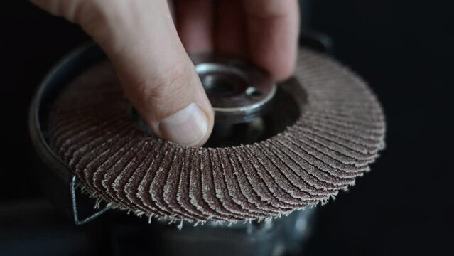 The master installs the cutting wheel in the angle grinder