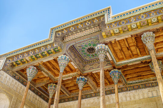 Close-up view of the carved wooden columns and painted ceilings of the street gallery (iwan) of the Bolo Haouz mosque, Bukhara, Uzbekistan