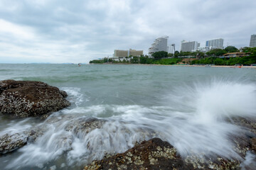 Ocean waves crashing against rocks on the sandy beach