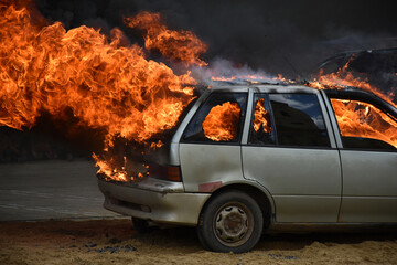 Obraz na płótnie Canvas Old car on fire after a traffic accident